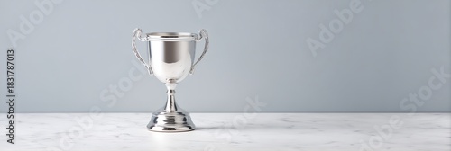 Silver cup with a handle sits on a white marble counter