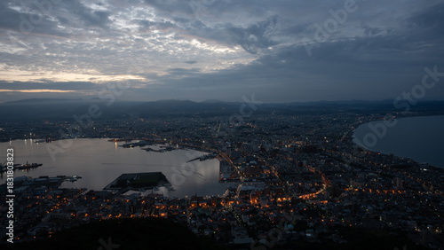 Dramatic sunset clouds and golden light illuminating the iconic cityscape of Hakodate, Hokkaido, viewed from Mount Hakodate.