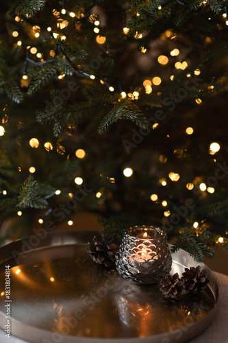Christmas holiday aesthetic festive background in dark tone, blurred Christmas tree with golden garland light bokeh, bronze tray with candle light, soft selective focus, copy space