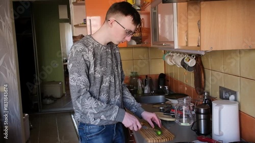young man in the kitchen is preparing food for himself