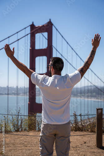 Man Raising Arms in Joy Facing Golden Gate Bridge
