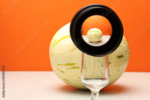 Cuadro en lienzo Still life with fruit – Dimo melon and concave lens on orange background