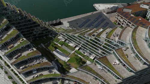 Aerial tilt up shot, flying over modern residential building in the Aarhus Docklands neighbourhood on a sunny day in Aarhus, Denmark.