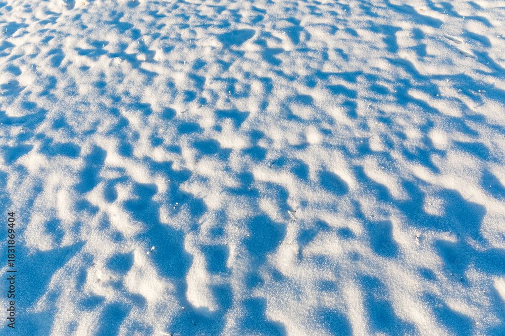Obraz premium Snow on the surface in sunny weather. Snow creates beautiful shadows. Atmosphere of silence and tranquillity. Background