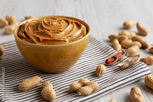 Картината върху платно Creamy Brown Peanut Butter in a Bowl, low angle view.