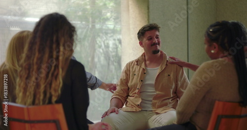 Cuadro en lienzo Man overwhelmed with emotion in group therapy, sitting with head in hand during