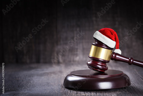 Santa Claus Hat on wooden judge gavel closeup on rustic background. Closeup. Christmas and New Year celebration