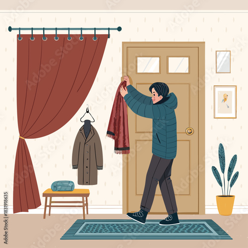 Un hombre cubre la puerta de entrada con una manta térmica o cortina gruesa para protegerse del frío en el interior de su hogar.
