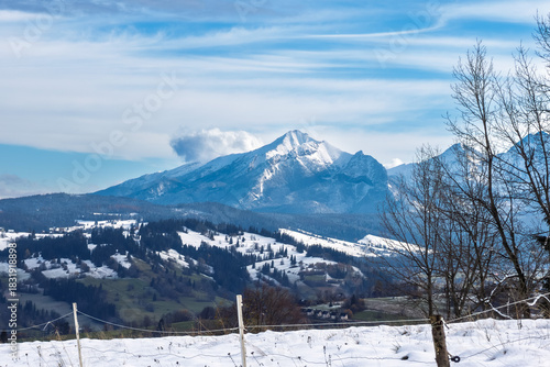 The majestic peak of Kriváň (Krywań) dominating the High Tatra Mountains, Slovakia. Wintry landscape from a Polish viewpoint, featuring snow and dramatic clouds.