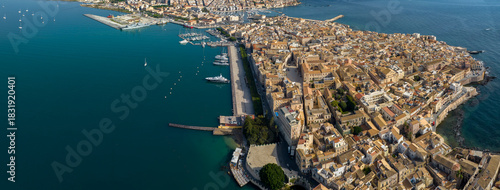 Aerial view of the island of Ortygia. This is the historic center of Syracuse, Sicily, Italy. The city overlooks the Mediterranean Sea and contains many historical landmarks. It's a summer morning.