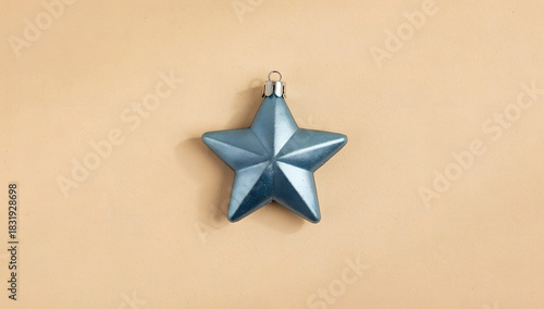 Blue holiday star decoration on soft beige background. Minimal concept idea