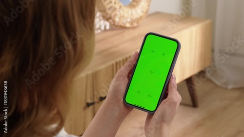 Woman use digital tech cell phone green screen mock up talk video call. Hand press click phone web site middle center. Girl hold mobile. Chroma key page. Cozy home background. Online app copy space.