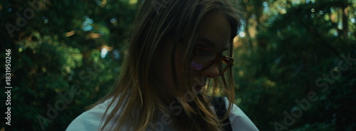 The girl appears framed by branches and leaves, creating a nature-filled scene in Yoyogi Park.