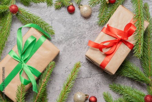 Christmas composition. Gift boxes, fir tree branches, red and gold decorations on grey background. High quality photo
