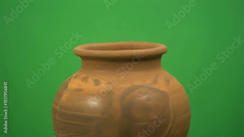 Ancient clay pottery vessel with decorative ornaments on a green screen