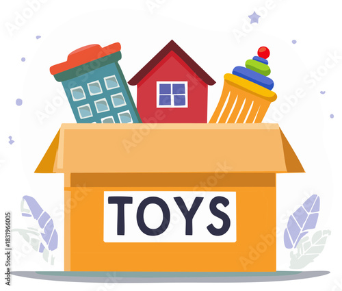 Colorful toys collection in a cardboard box featuring buildings and a stacking cup for donation or storage