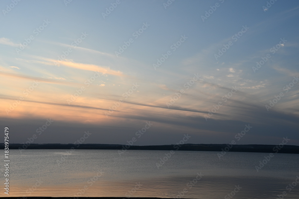 Naklejka premium High-contrast view emphasizing the vastness of the water and the intense cloudscape. The composition conveys a sense of calm before the storm or natural drama, ideal for environmental themes.