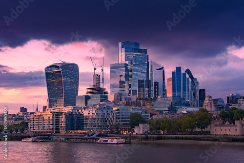 London city skyscrapers by the Thames. Modern skyscrapers rise against with sunset in London City, reflecting on the River Thames.