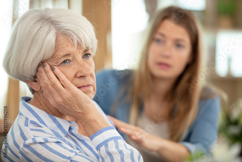 young adult woman consoles sad senior adult female