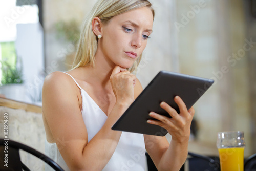 Free Download woman in cafe looking at a tablet pc - GFXLoad