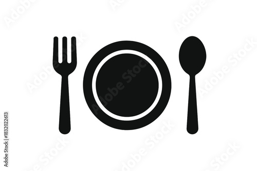 Fork and spoon beside a plate on a table ready for a meal in a simple dining setting