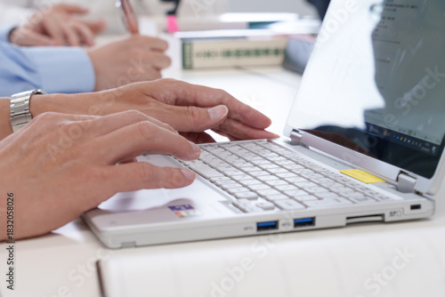 会議室でノートパソコンを操作する若い男性の手元