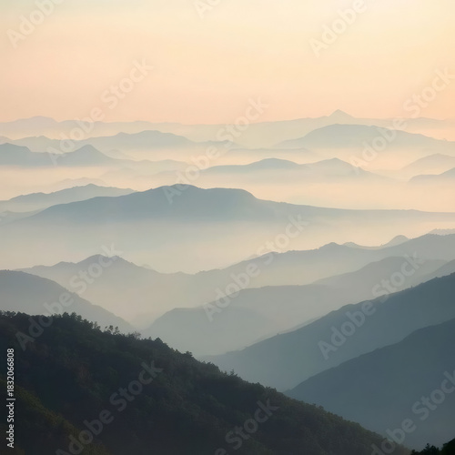Majestic layers of mountains under soft sunlight creating a tranquil landscape in early morning haze