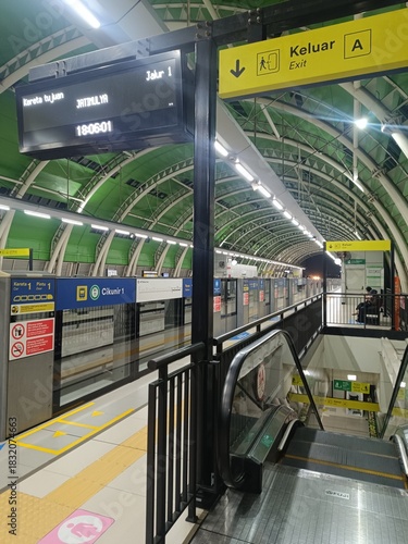 Busy Subway Station Platform with Escalator and Information Display, Reflecting Commuting and Transit in a Modern Urban Setting