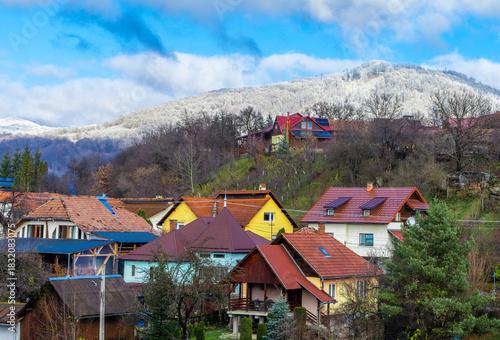 Wallpaper Mural A transitional season, likely late autumn or early spring, where the bare trees in the foreground contrast with the snow-capped hill in the background. Rural landscape with a few houses in late autumn Torontodigital.ca