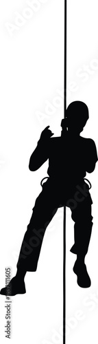 Silhouette of person rappelling down rope