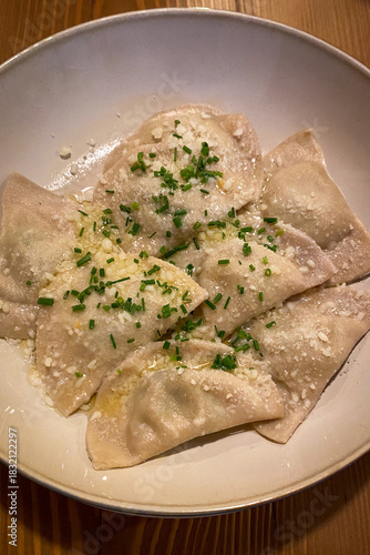 Traditional Tyrolean Schlutzkrapfen — spinach-ricotta filled pasta with brown butter, chive and grated cheese — served in South Tyrol, Italy