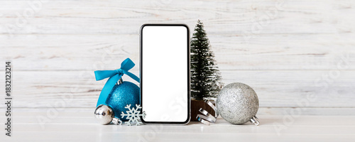 Digital phone mock up with rustic Christmas decorations for app presentation with empty space for you design. Christmas online shopping concept. Tablet with copy space on colored background