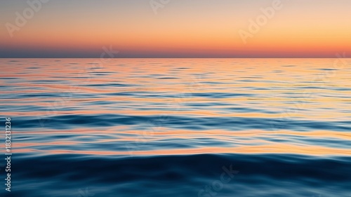 Fototapeta Naklejka Na Ścianę i Meble -  The calm ocean reflects the warm colors of the sunset, creating a tranquil and beautiful scene over the water with peaceful ambiance, in the evening time.