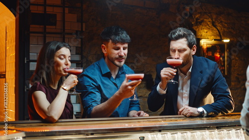 Bar clients drinking cocktails relaxing together on night club party closeup
