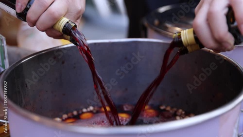 Chef Pouring Red Wine into Cooking Pot for Gourmet Recipe Preparation