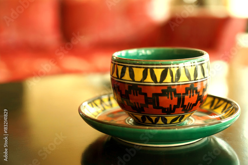 Colorful Patterned Ceramic Cup and Saucer in Warm Ambient Light