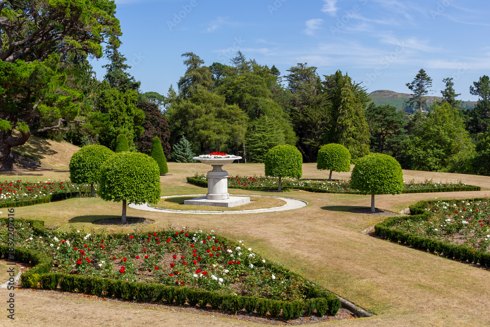 Fototapeta premium a panoramic view over the powerscourt gardens with colorful flowers an vases, ireland