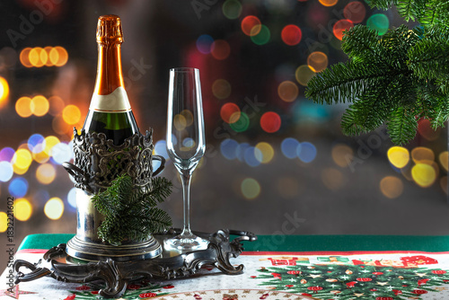 Bottle of champagne in an ice bucket on the New Year's table. Christmas and New Year celebration with champagne. The concept of the holiday.