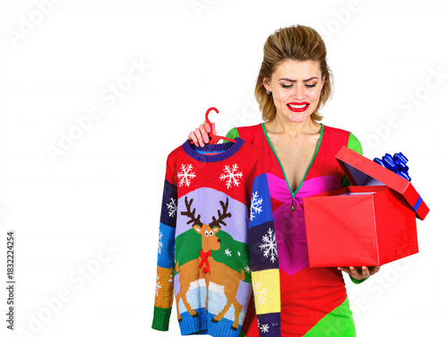 Ugly Xmas sweater. Christmas person with bad gift. Christmas woman with bad gift. Woman reacting to bad Christmas gift. Copy space.