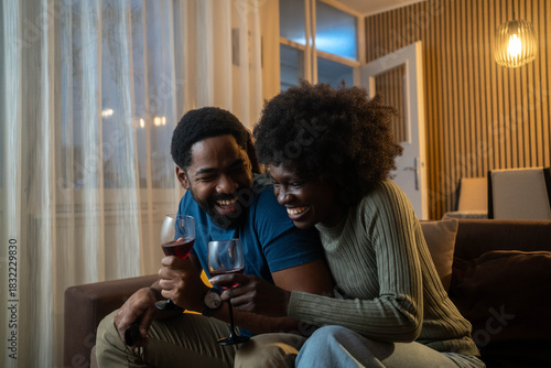 African american couple having romantic date at home while drinking wine 
