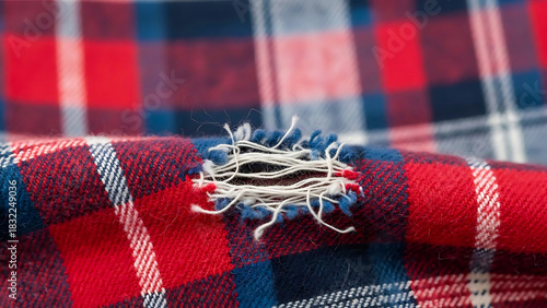 Hole in worn red and blue plaid fabric texture