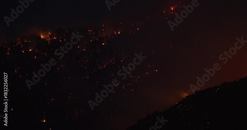 Orange glow of fires scattered across mountain side at night