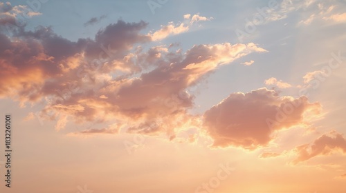 Soft, peachy clouds float gently across the sky as the sun begins to make its presence known.