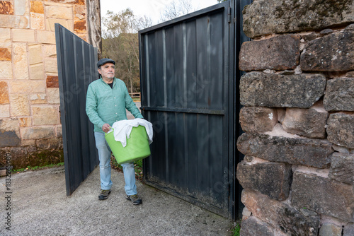 Wallpaper Mural Mature man carrying laundry basket through gate Torontodigital.ca