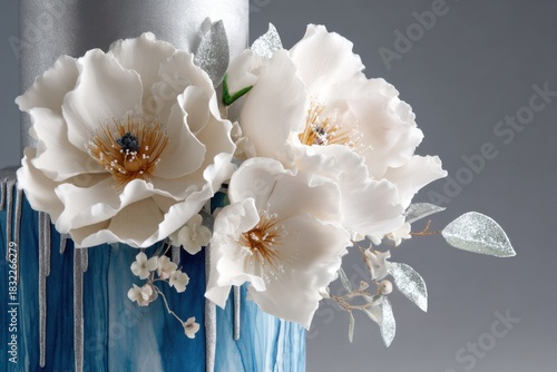 Wedding cake adorned with cobalt marbled fondant and metallic silver drip, featuring elegant white flowers, perfect for celebrations and special occasions with copy space