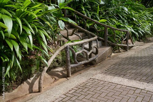 Vara Blanca, Costa Rica - November 14, 2024 - the La Paz Waterfall Gardens Nature Park - stone staircase with a unique wooden railing in a lush tropical garden