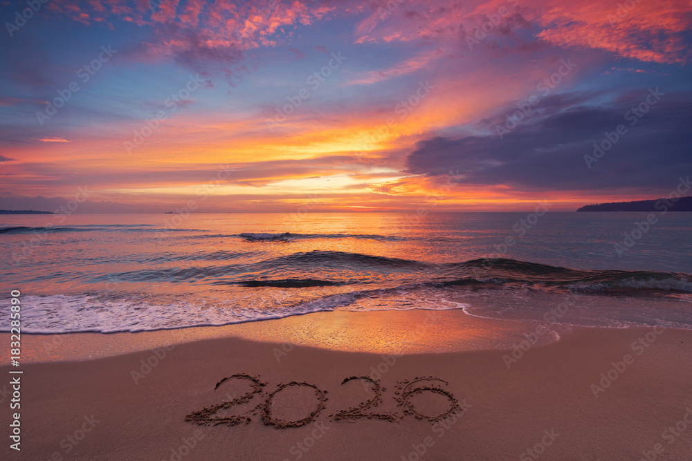 Obraz premium Scenic sunrise over the sea horizon and beach text Happy New Year 2026 on the sand
