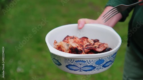 The chef transfers fried meat from the grill to a plate. Grilled Steak Transfer from BBQ to Plate.