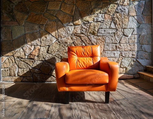 orange armchair bathed in sunlight against a stone wall