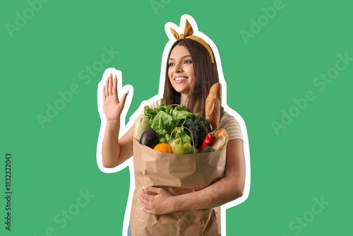Beautiful young woman with grocery bag waving hand on green background